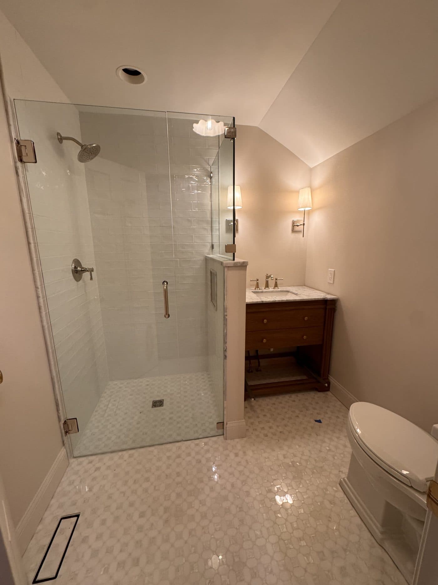 Master bathroom remodel with white zellige subway tile, frameless glass shower, penny mosaic floor, and walnut floating vanity in Northeast Ohio