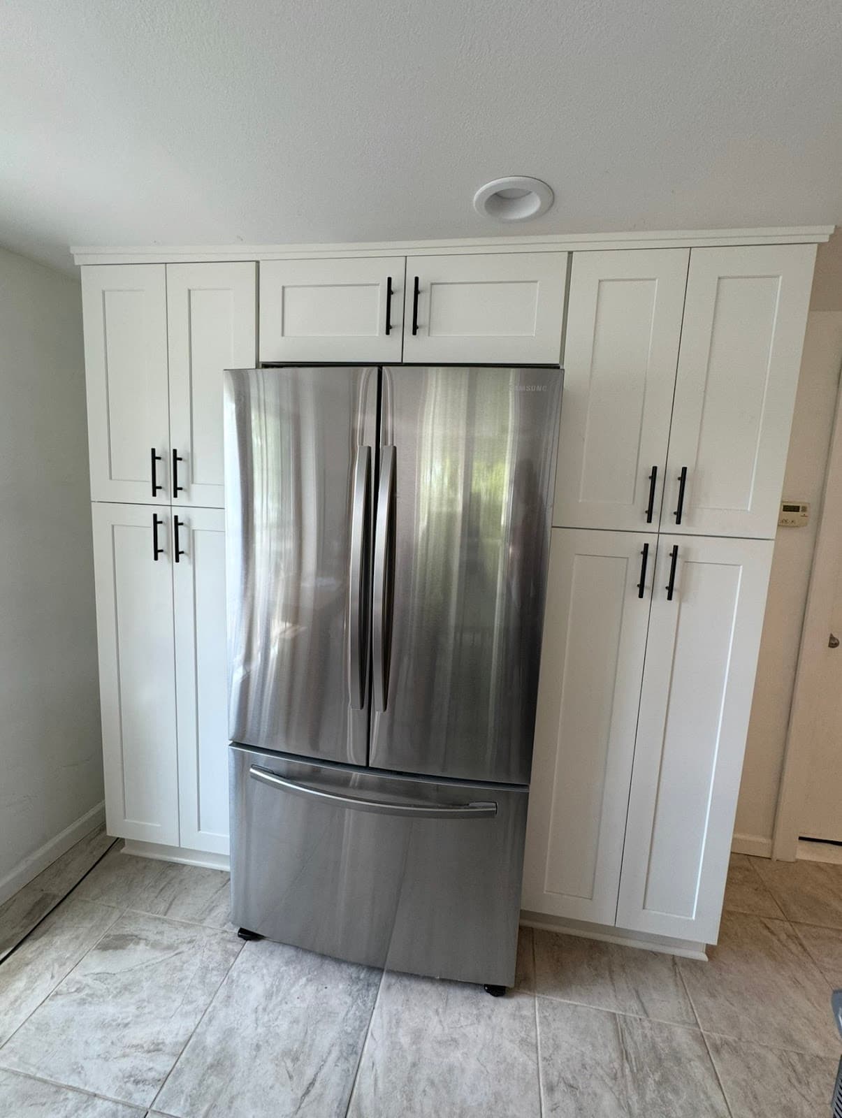 Kitchen remodel with white cabinetry, premium countertops, and tile backsplash in Cuyahoga County