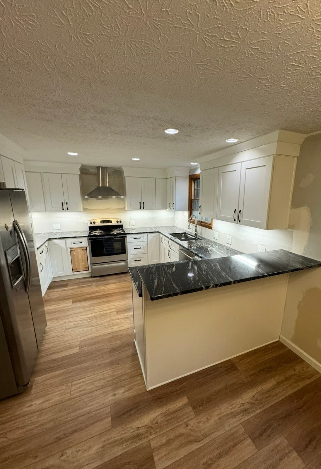 Kitchen remodel with custom cabinetry, quartz island, and hardwood floors in Northeast Ohio