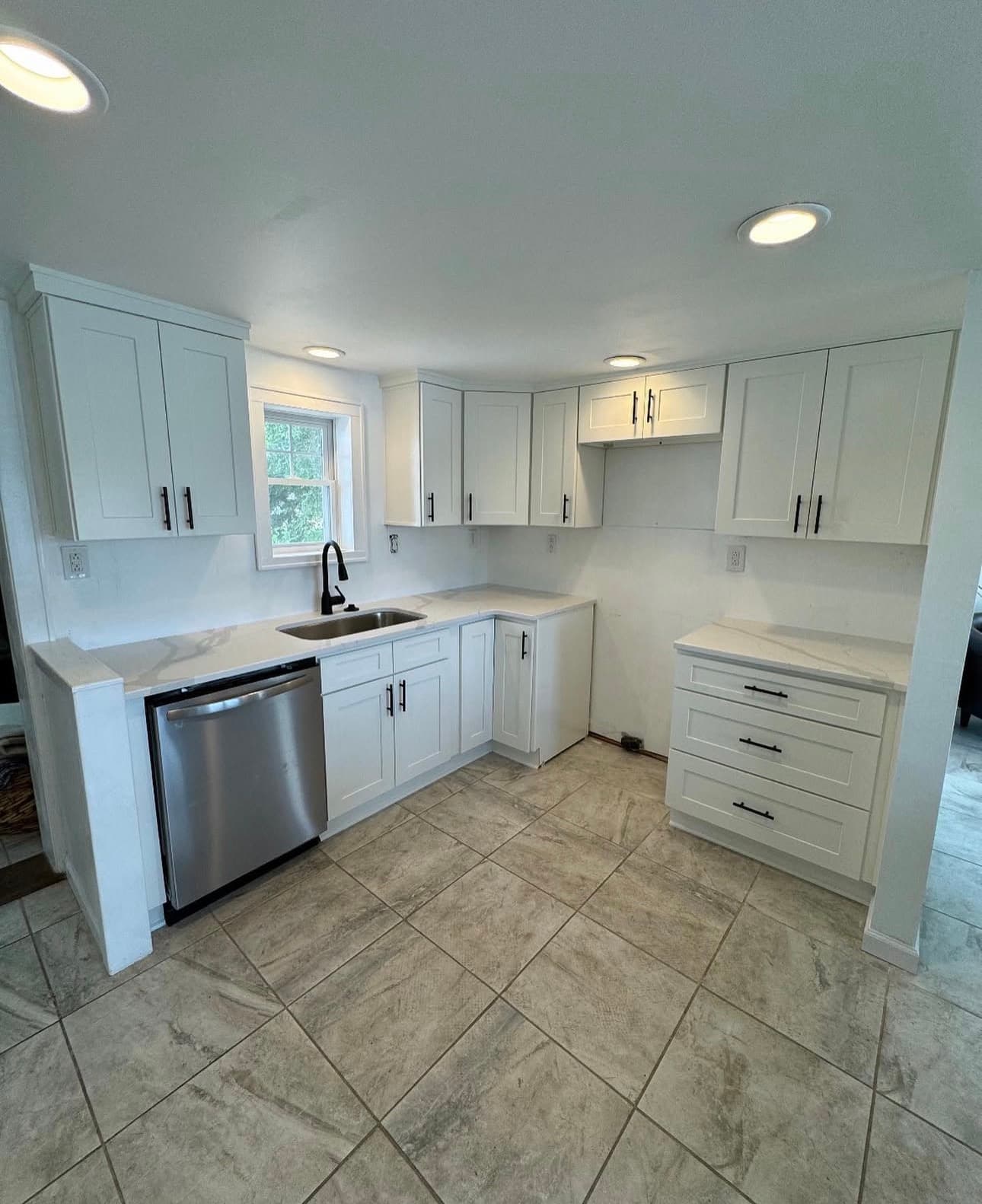 Kitchen remodel with white shaker cabinets, stone countertops, and tile backsplash in Lake County Ohio