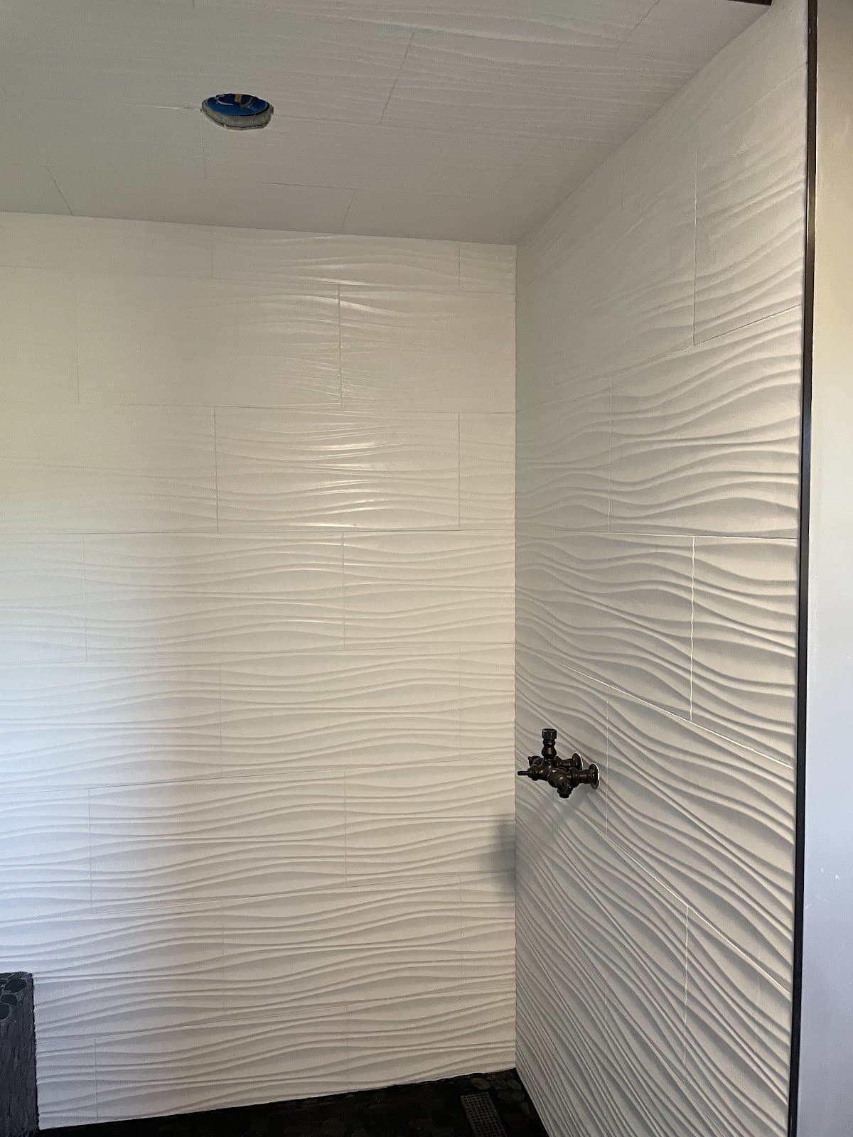 Shower remodel with white 3D wave-texture large-format tile walls in Lake County Ohio